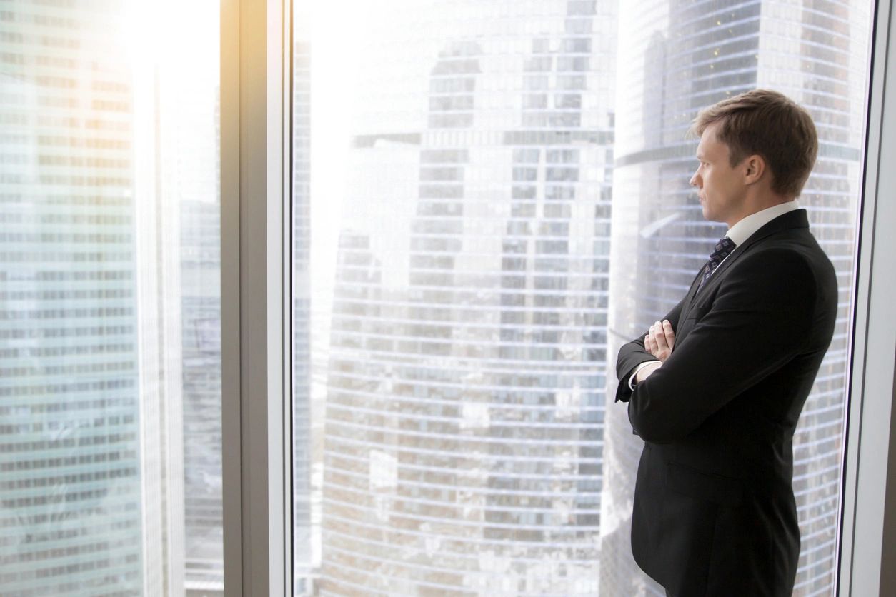 A man in a suit looking out of the window