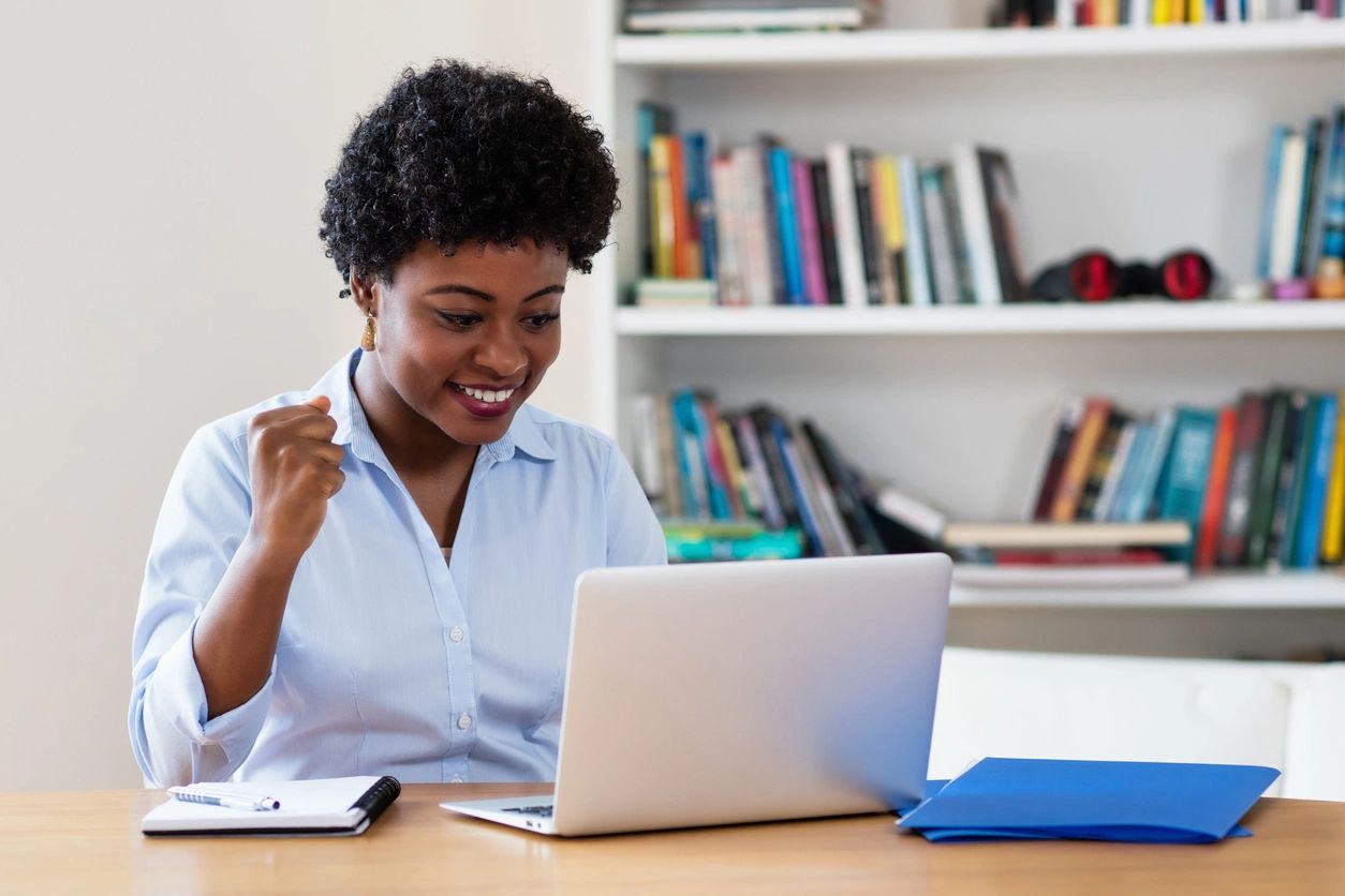 A woman sitting at a table with her laptop.