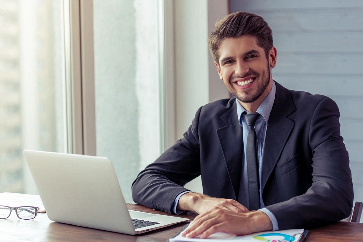 A man sitting at a table with a laptop.